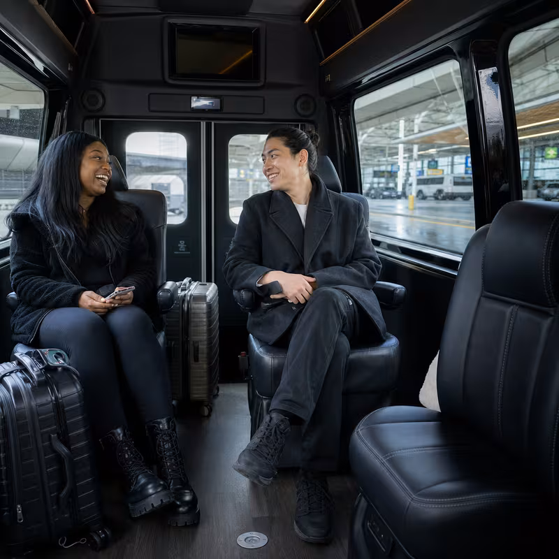 Passengers loading luggage while boarding an Queens group shuttle