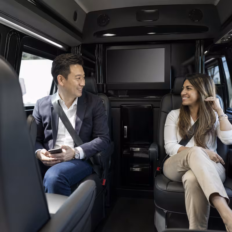 Group boarding a white charter bus for Corporate Transportation transportation in Queens