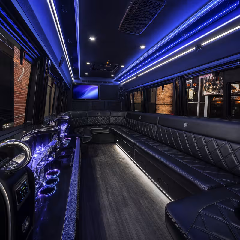 Party bus interior with wraparound leather seating and LED lighting in Queens