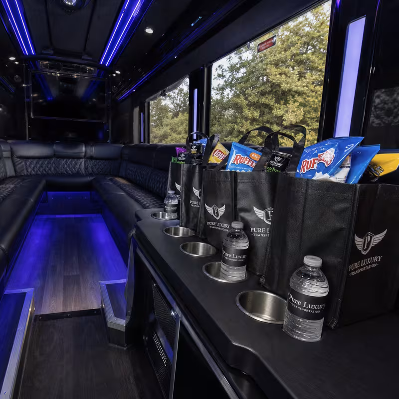 Party bus interior with wraparound leather seating and LED lighting in Queens